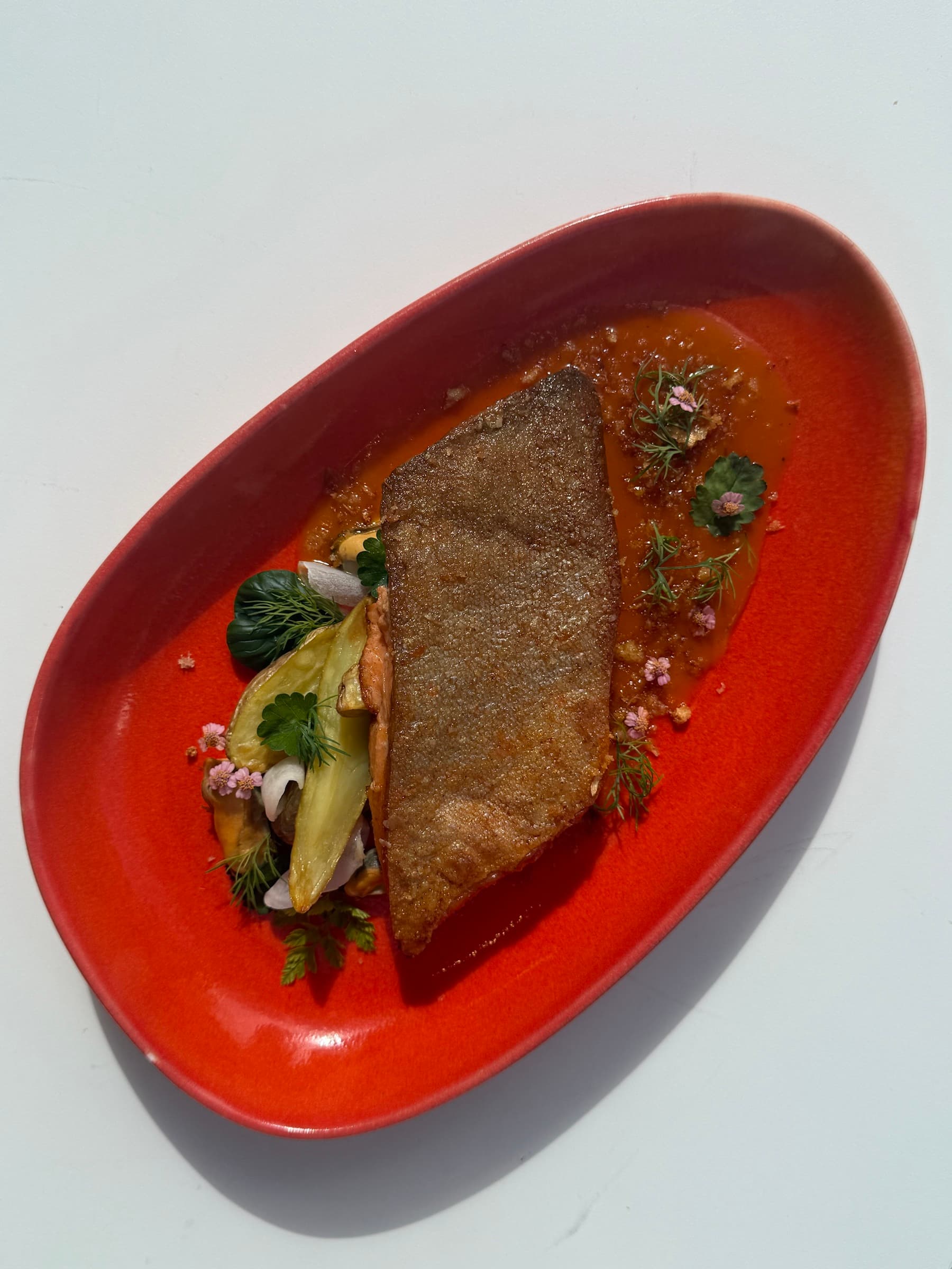 A finished dish on a red oval plate