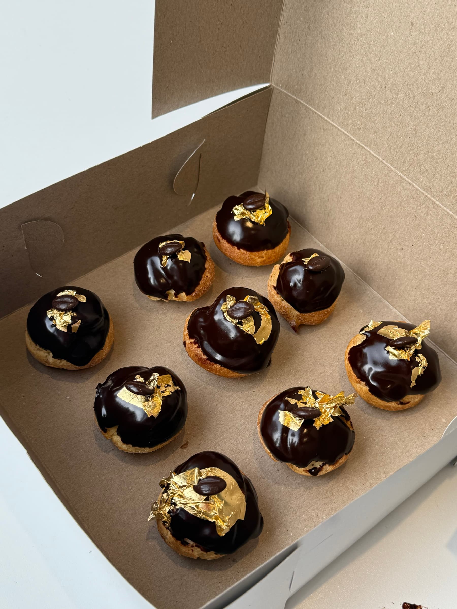 Chocolate pastries with gold leaf in a box